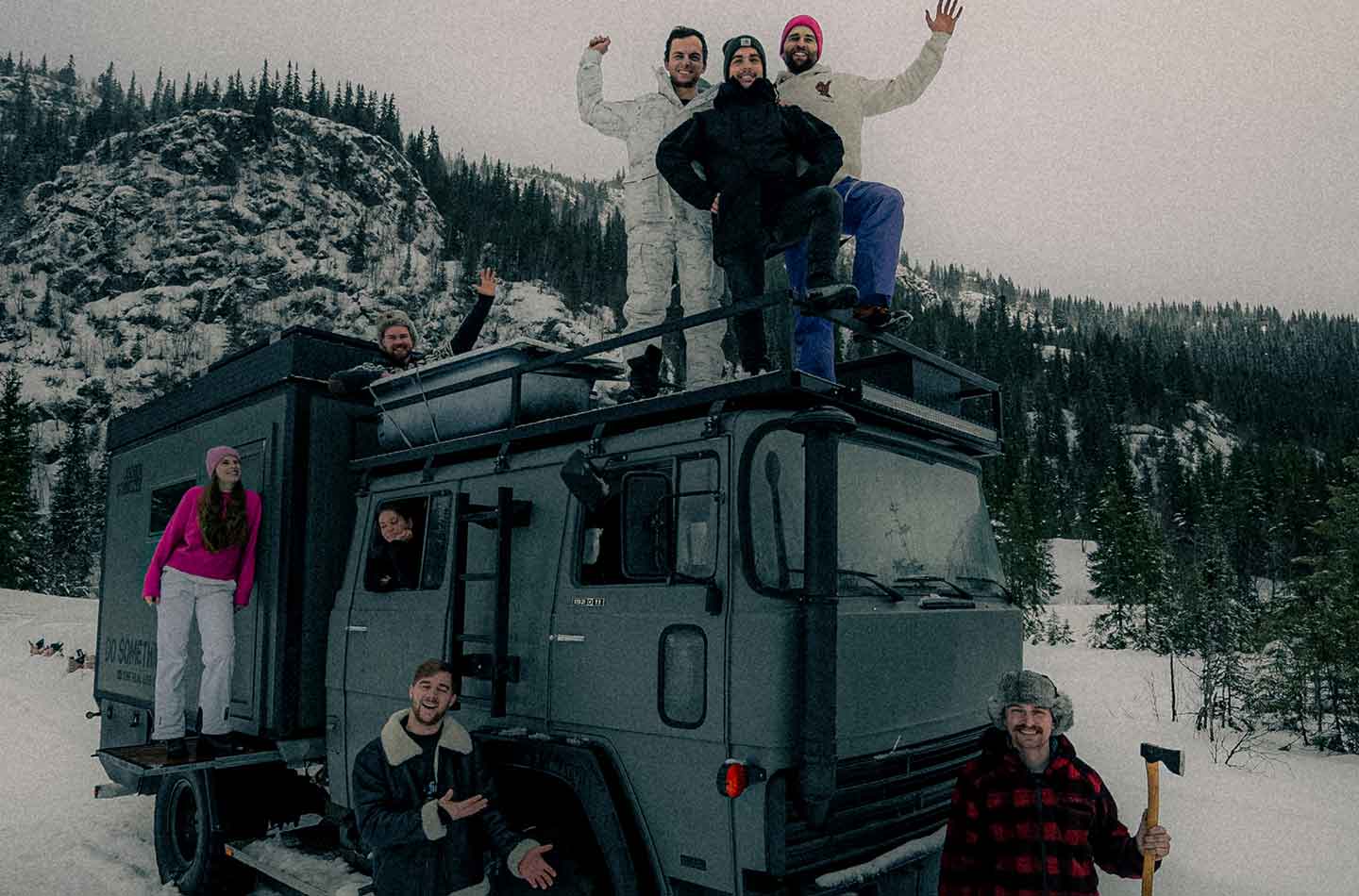 Menschen auf einem Truck in Schneelandschaft.