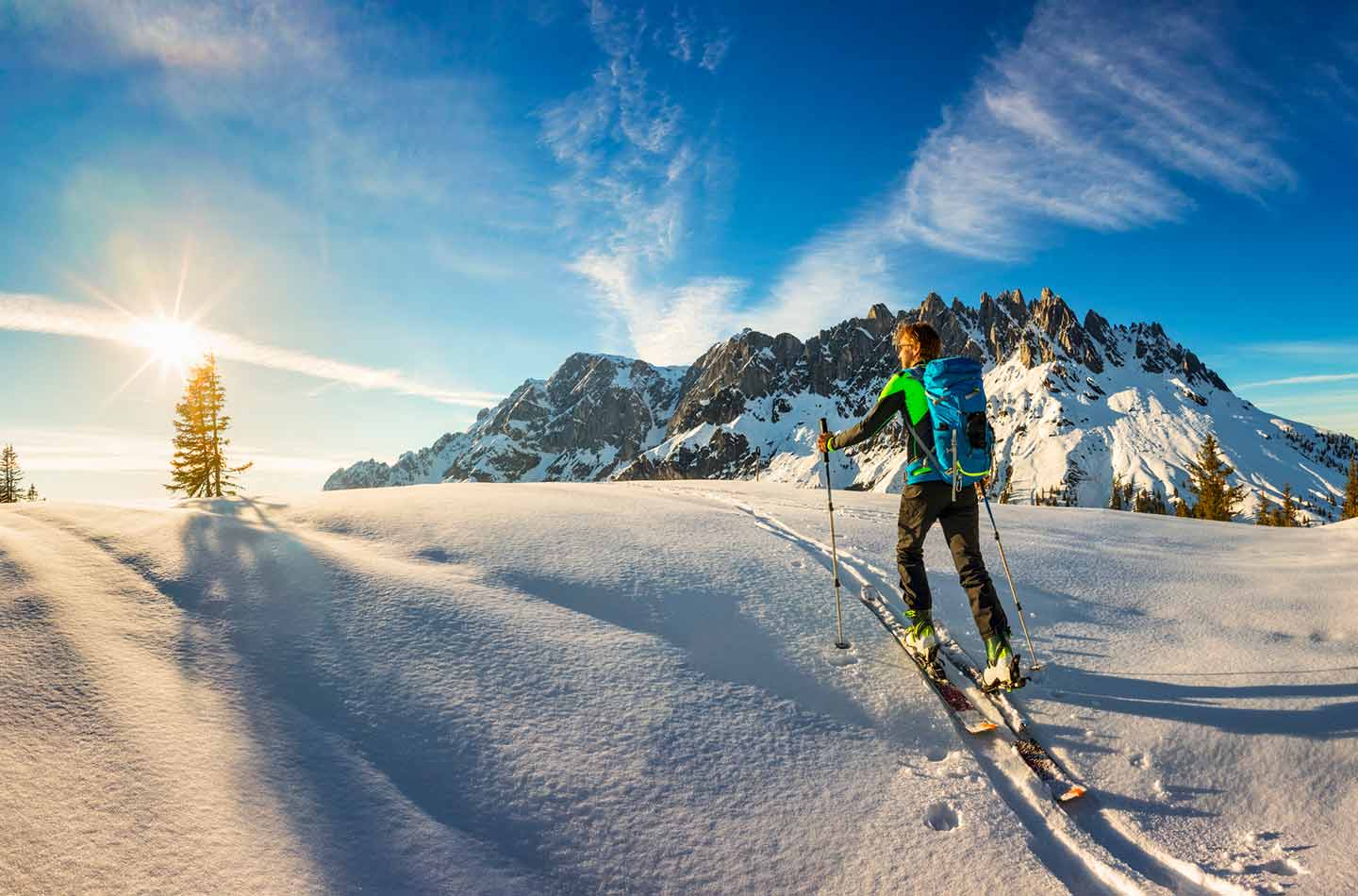 Skitour in den Bergen mit der Sonne im Hintergrund