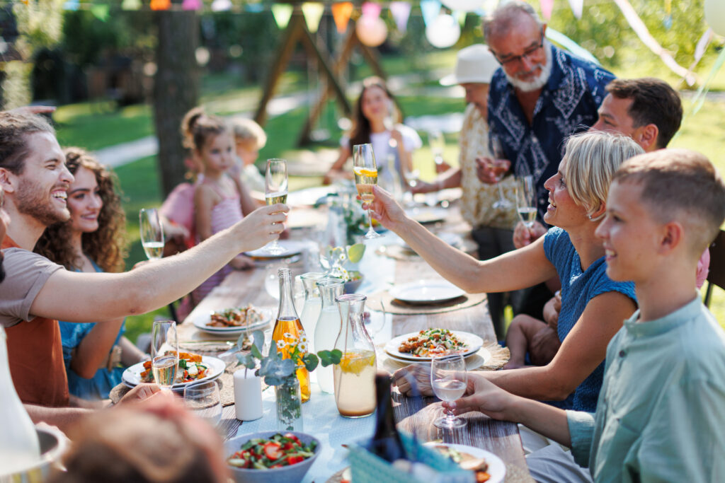 Gartenparty als Aktivität im Sommer: Familie stößt gemeinsam an. 