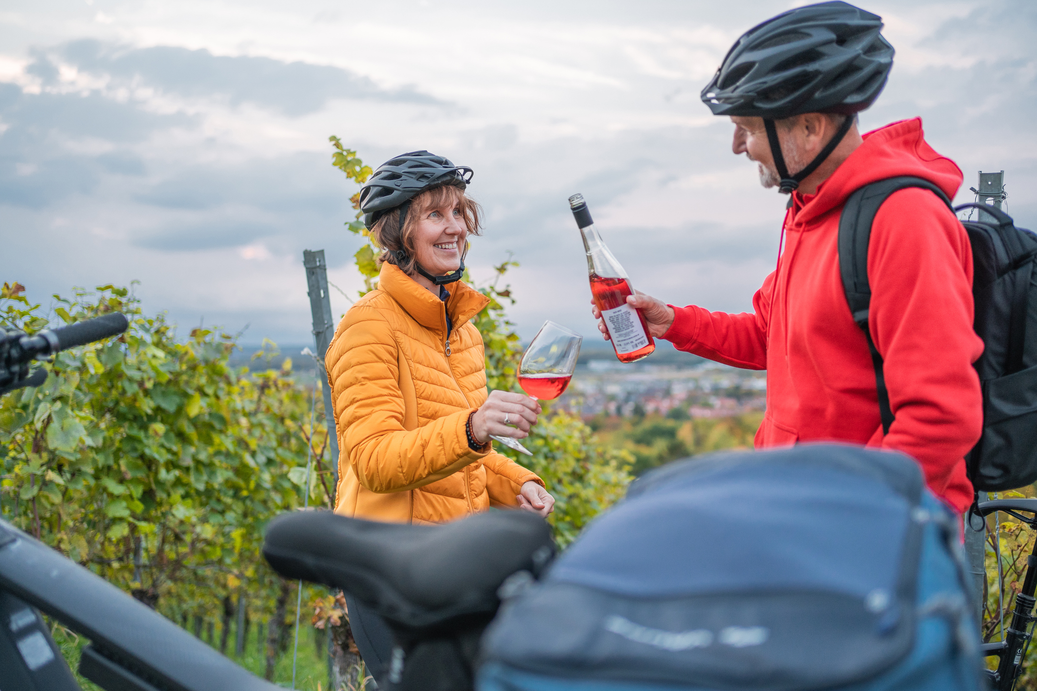 Die Radwege Schwarzwald führen durch Weinreben: Ein Ehepaar teilt sich in ihrer Fahrradkluft eine Flasche Wein. 