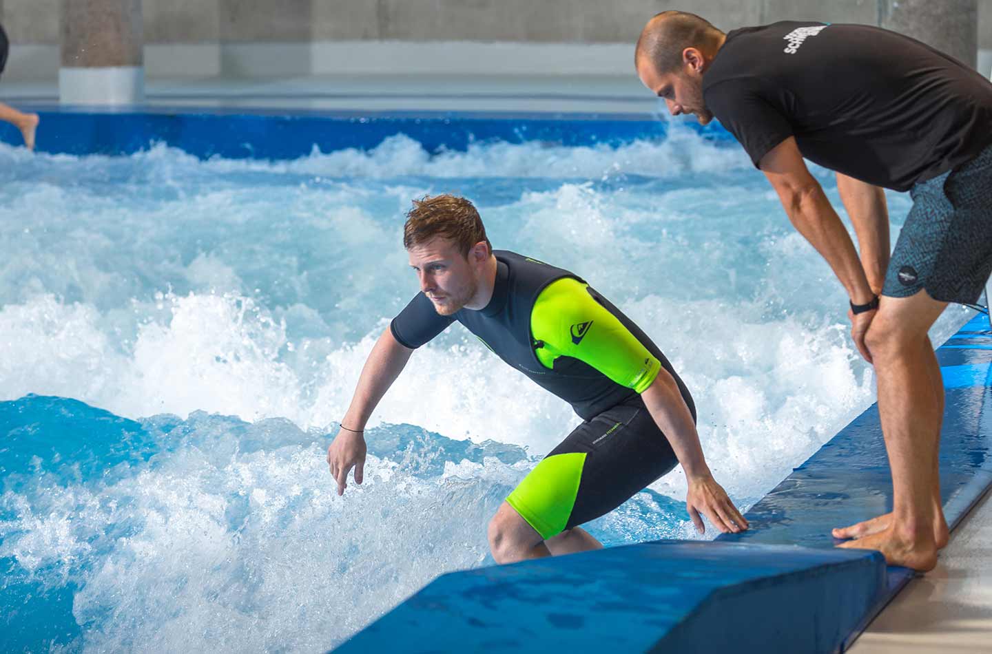 Surfer Anfänger bekommt vom Profi gezeigt, wie er richtig surft