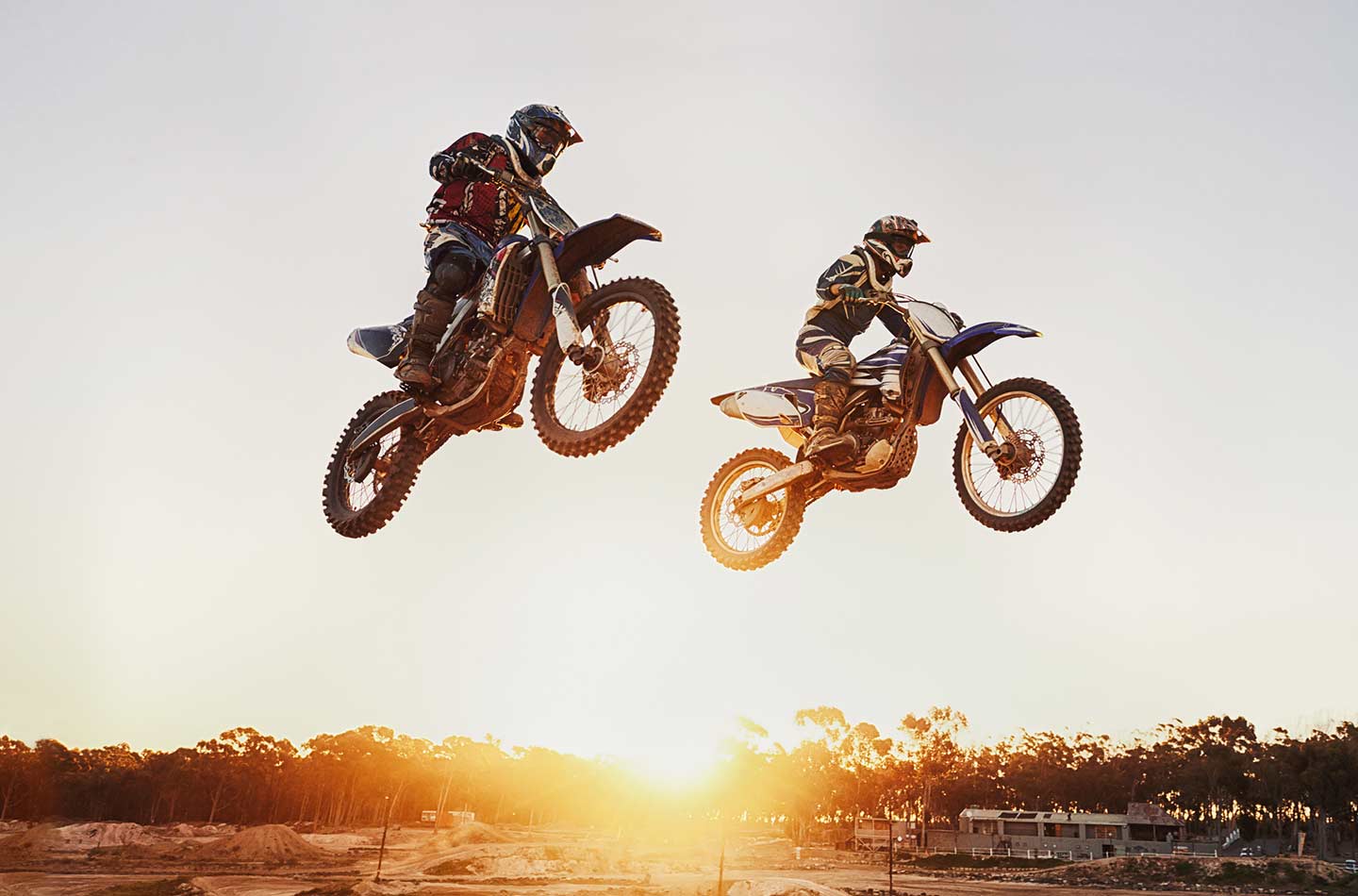 Zwei Leute fliegen mit einem Cross Motorrad beim Motocross durch die Luft