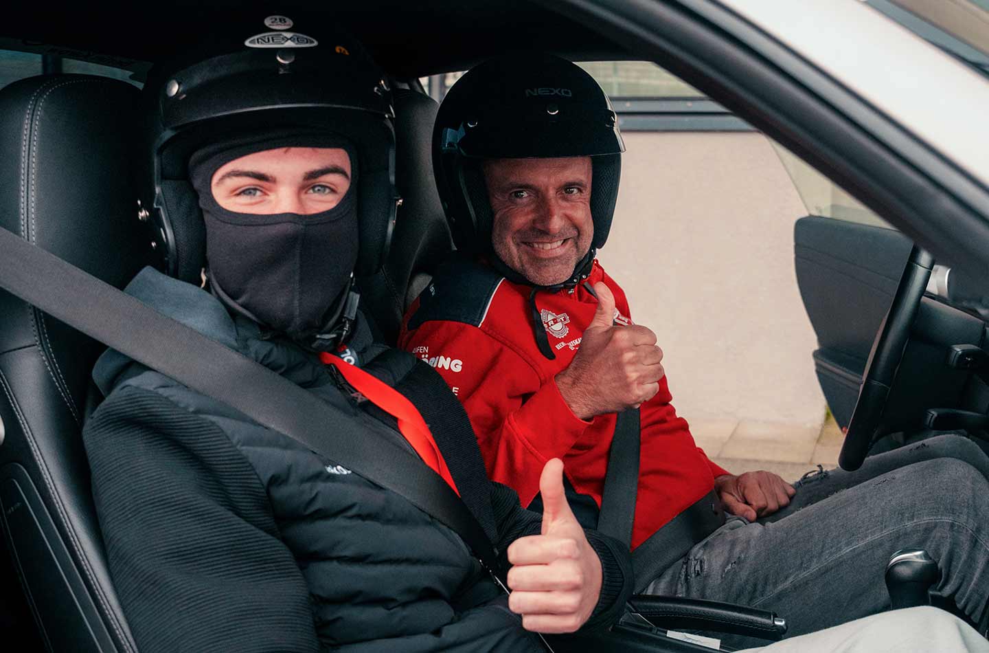 Ein Mann und ein Jugendlicher sitzen in einem Rennwagen