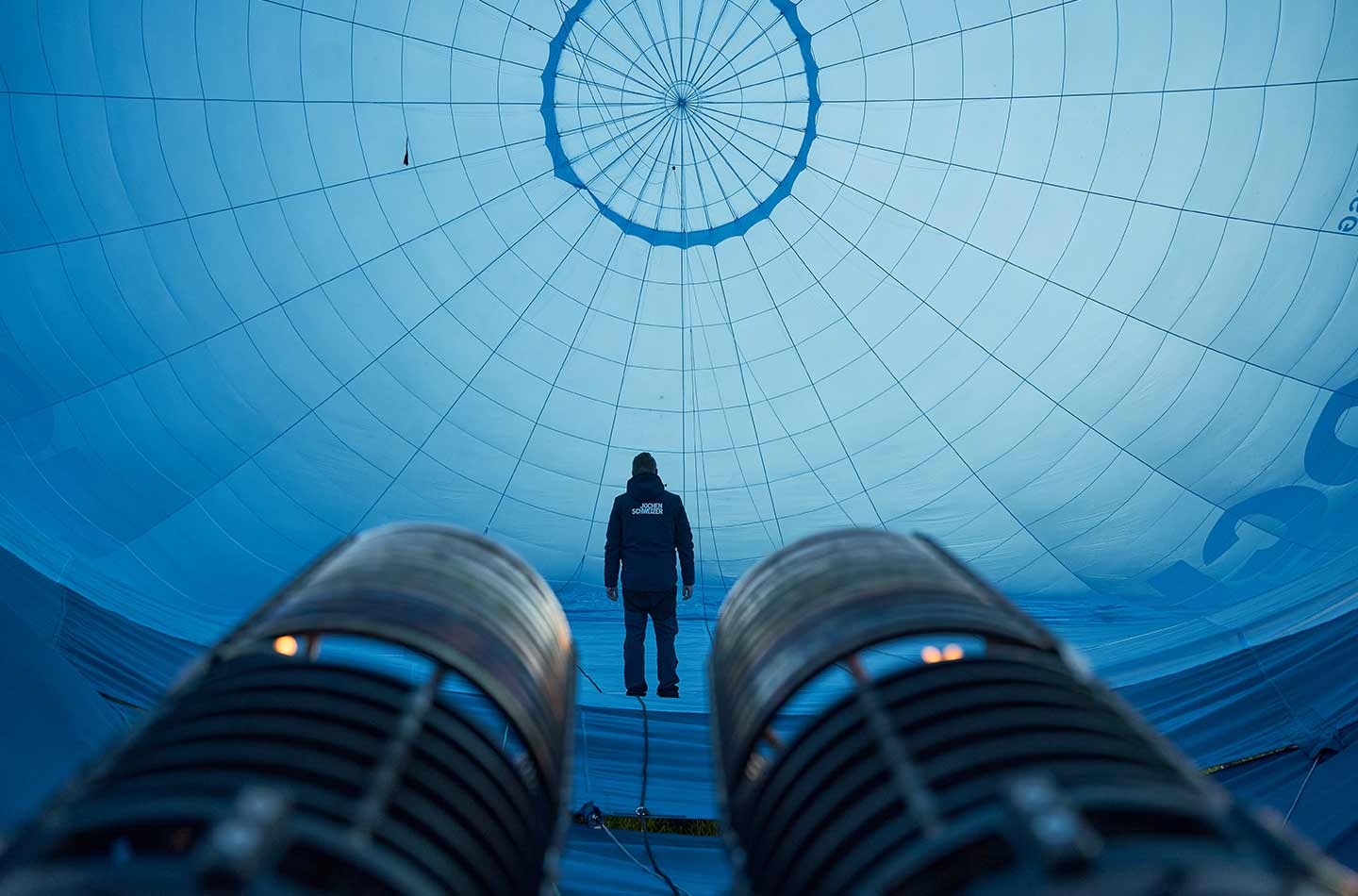 Ein Mann steht im Heißluftballon, der gerade aufgeblasen wird