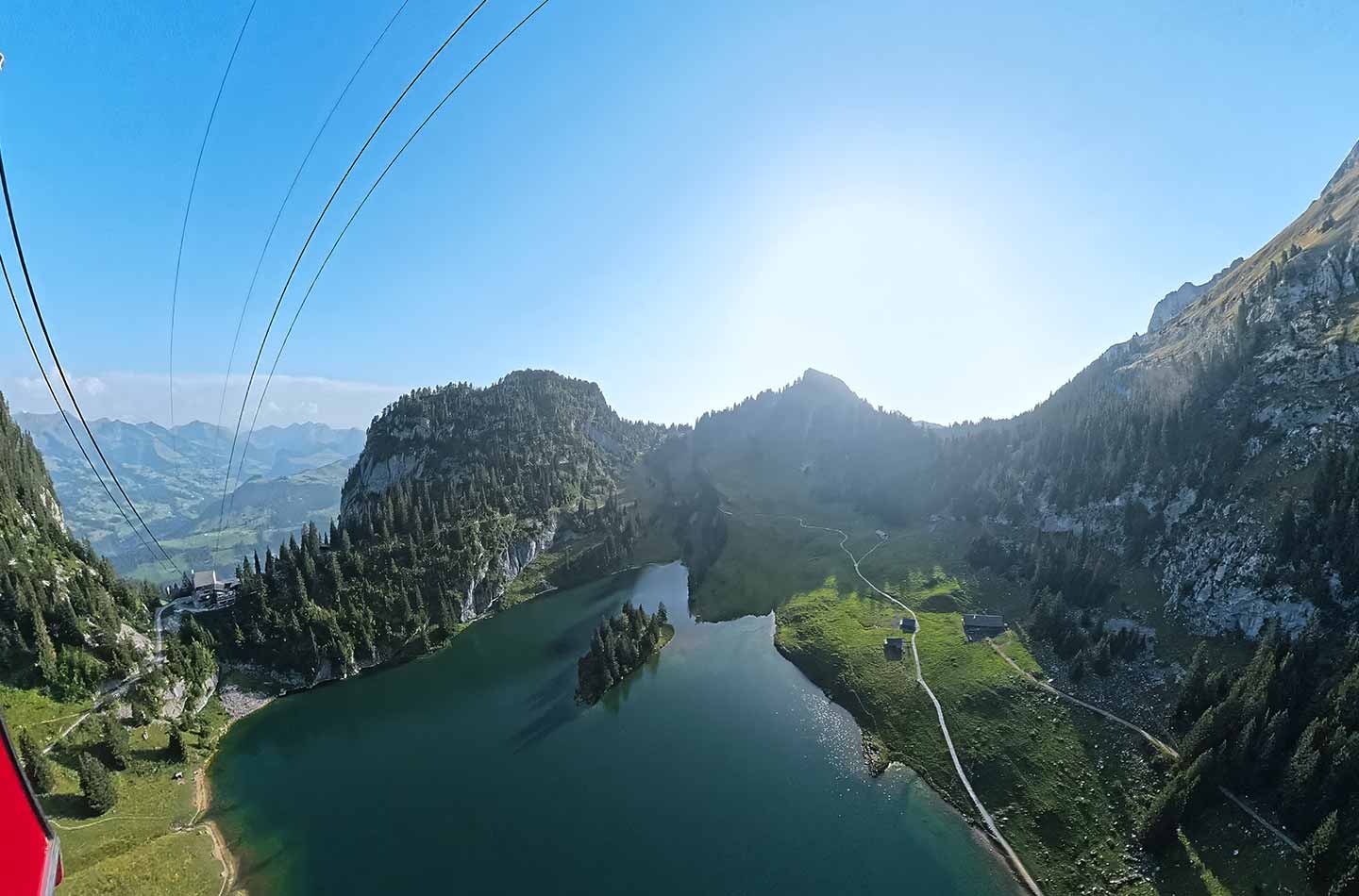 Foto aus einer Gondel auf eine Bergkette und einen Bergsee